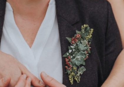 Lady's corsage / buttonhole featuring succulents and greenery at Bridge House Barn, Kibworth